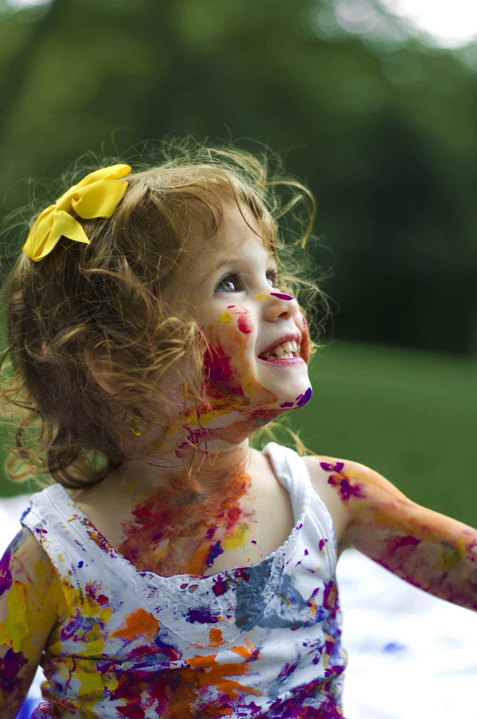 A young girl joyfully covered in paint after an art session